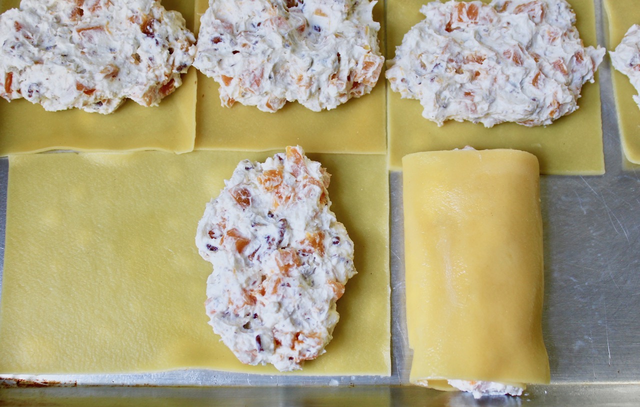 rolling filling into cannelloni